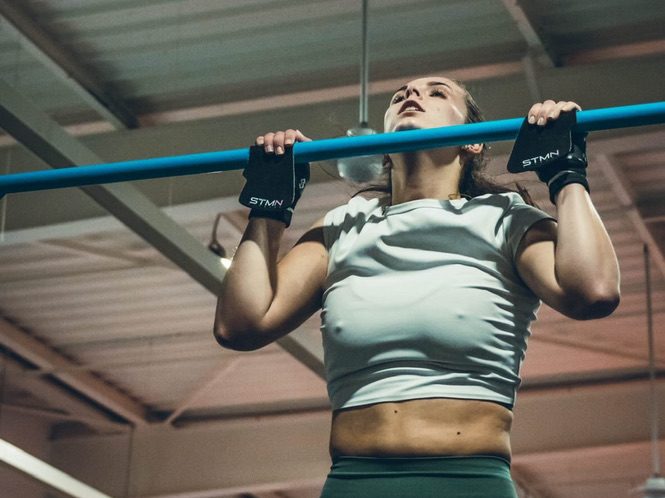 Athlète réalisant une pull-up stricte, menton au-dessus de la barre